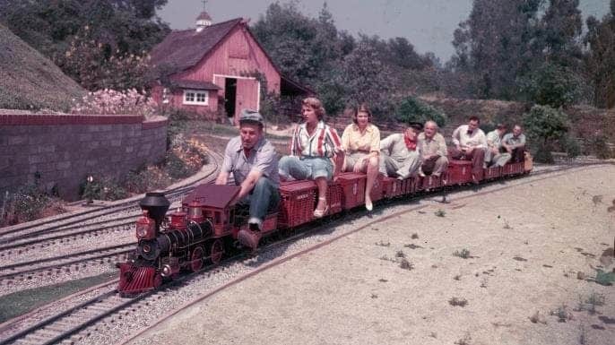 Disney drivers a miniature railroad filled with passengers at his California home