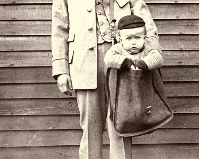 Uniformed Letter Carrier with Child in Mailbag - Smithsonian Institution