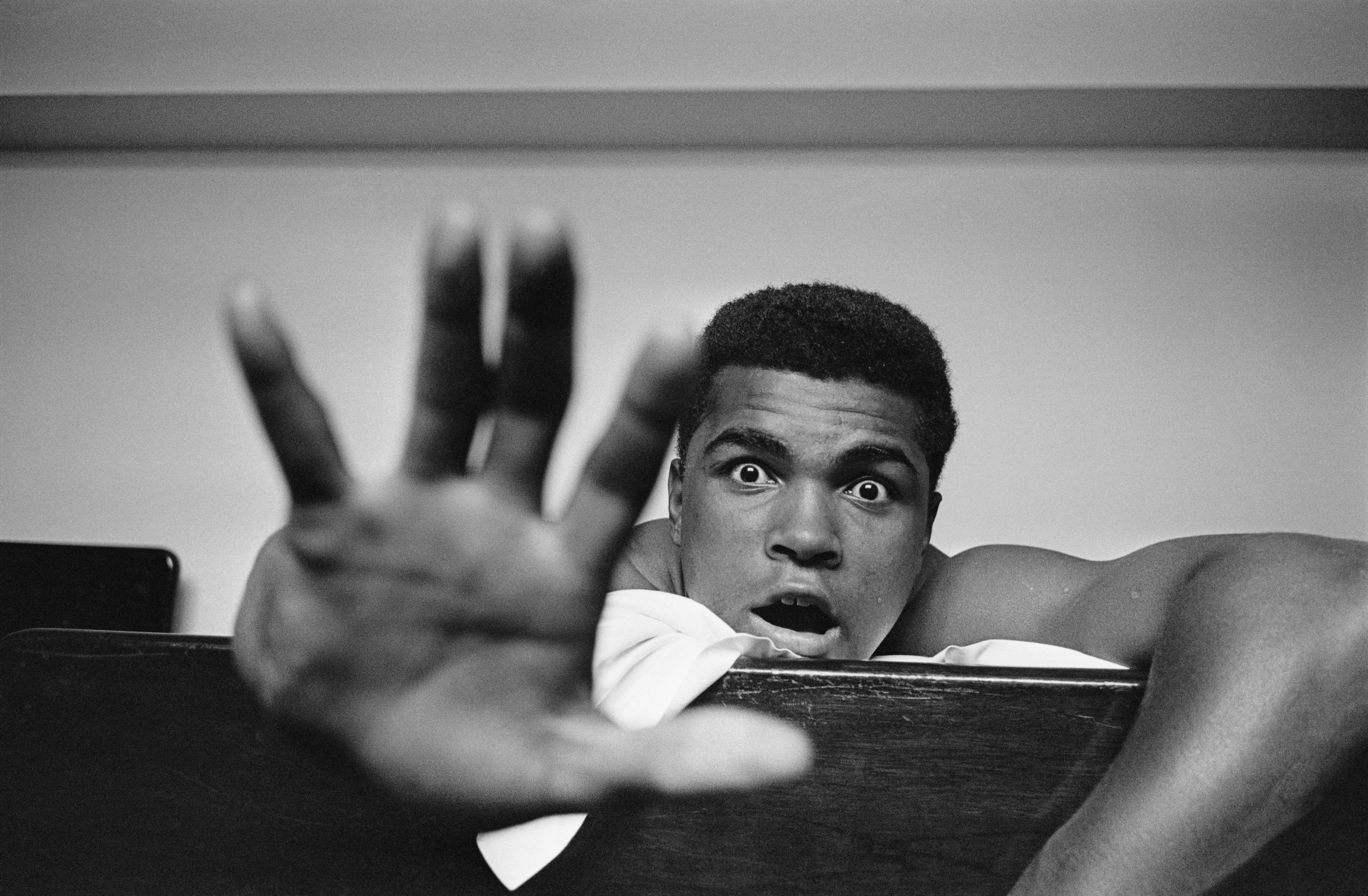  Give me a five: Ali in his hotel room holding up five fingers to show how many rounds it will take him to knock out British boxer Henry Cooper in 1963