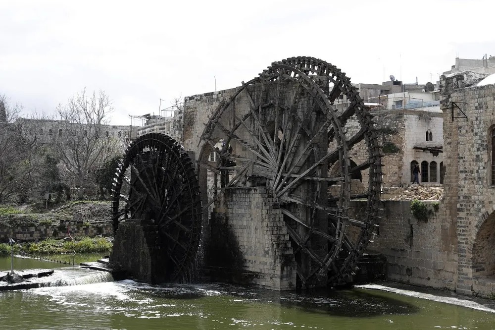 The water wheels al-Jabiriya and al-Sahiuniya. In the background, excavations are taking place in the Iron Age citadel on the mount.