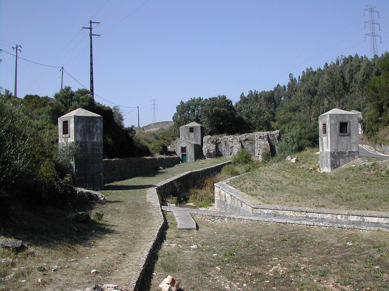 Part of the Roman Dam of Belas complex, showing the ventilation structures (foreground) and the remaining dam segment (background)